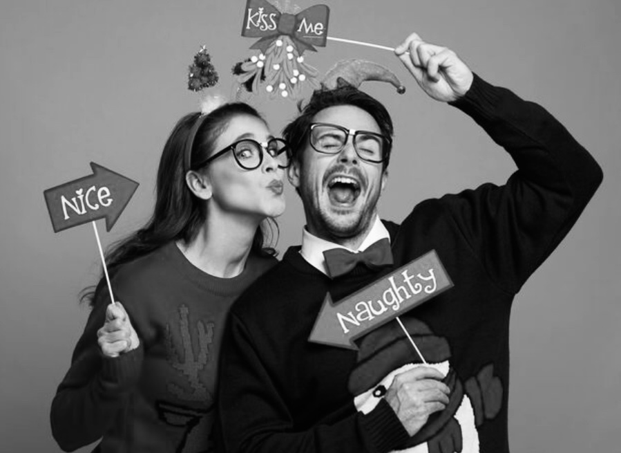 Playful couple with holiday props